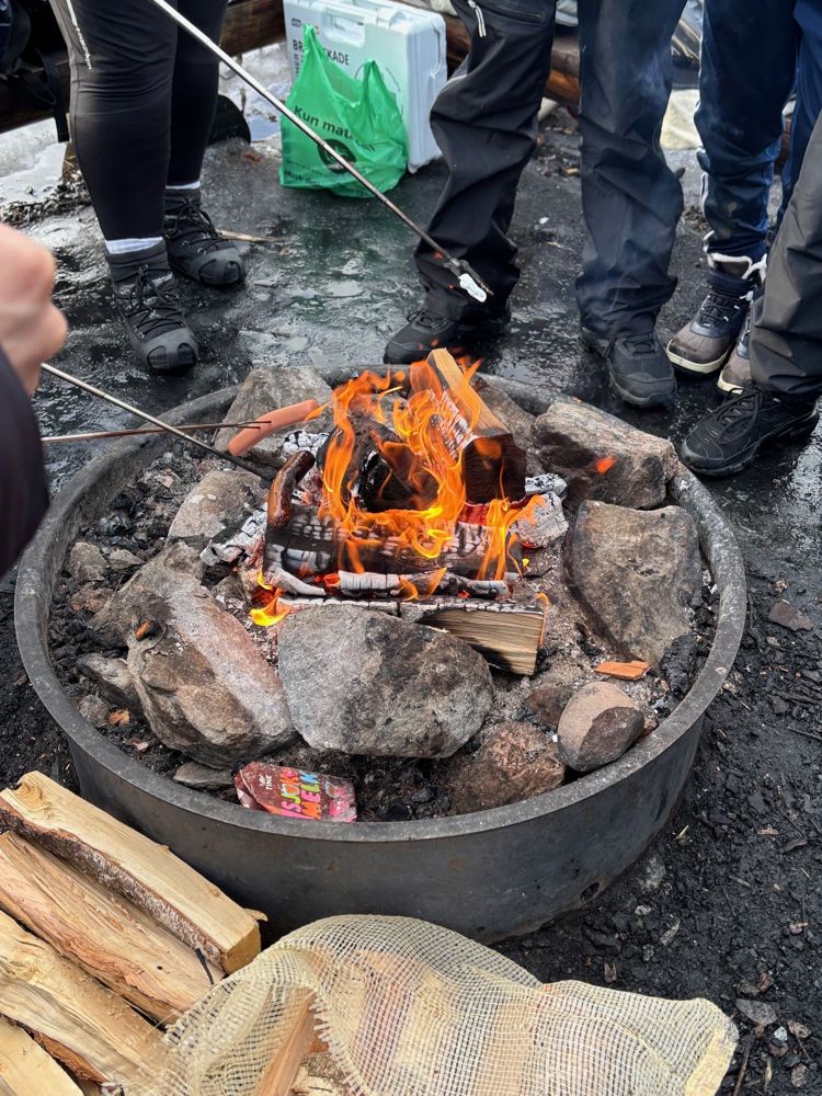 en bålplass med en gruppe mennesker rundt